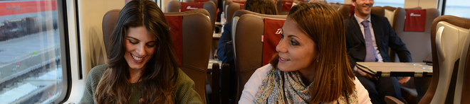 Two passengers chat on a Trenitalia train in Italy 